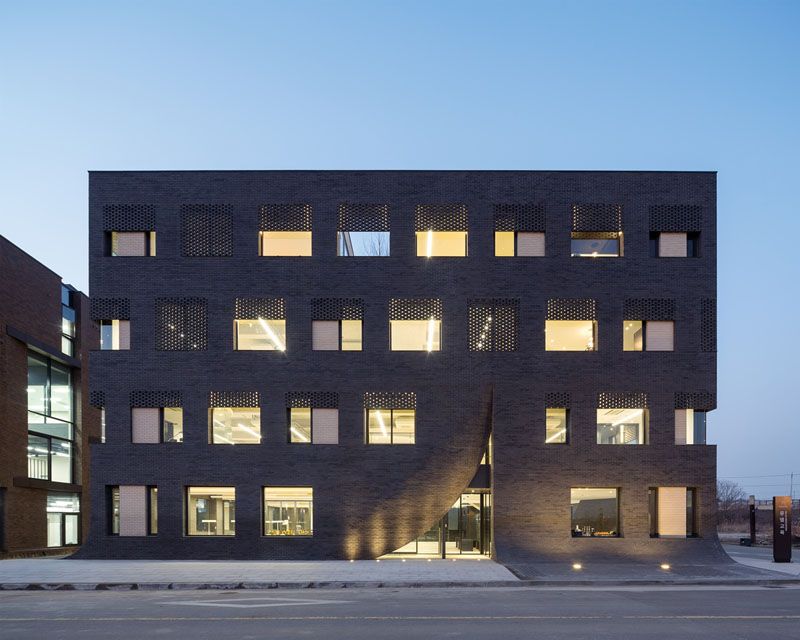 The entrances to this brick building are pulled away like a curtain
