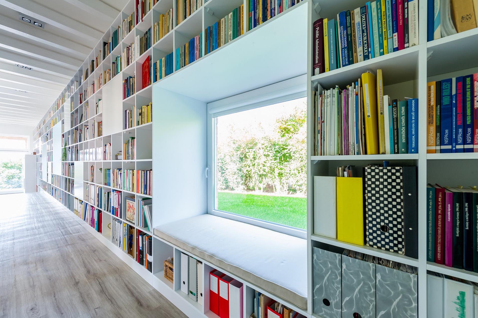 This Long Wall Of Shelving Incorporates Storage, A Fireplace, Windows, And Seating